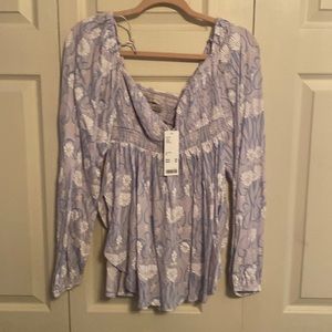 Empire waist with bell sleeves and a u shaped hem, and ruching across the bust.